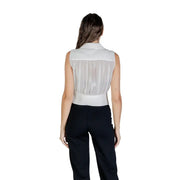 Woman wearing a white sleeveless sheer V-neck zip top with black pants for Fall Winter fashion