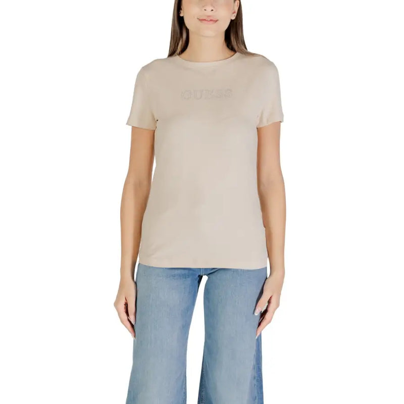 Women wearing beige short-sleeved T-shirt with light blue wide-leg jeans for Guess Active collection