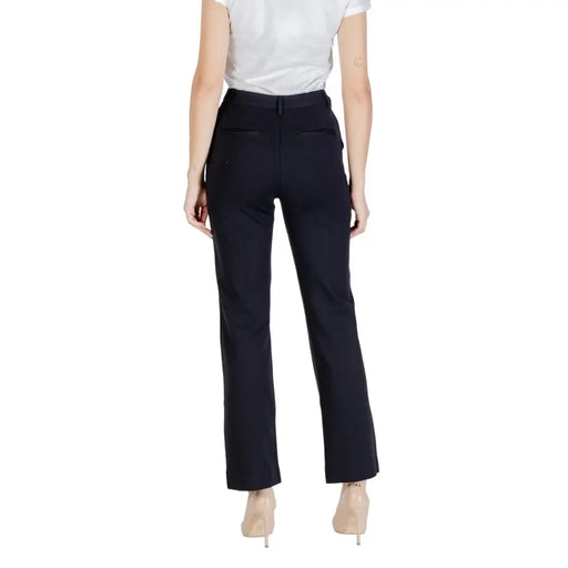 Women’s black dress pants from Guess Fall Winter collection featuring zip and button details
