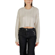 Woman wearing beige cable-knit cropped sweater and dark high-waisted wide-leg jeans for fall winter fashion