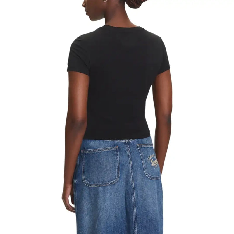 Women wearing black short-sleeved T shirt and blue distressed denim maxi skirt