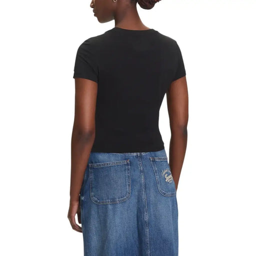 Women wearing black short-sleeved T shirt and blue distressed denim maxi skirt