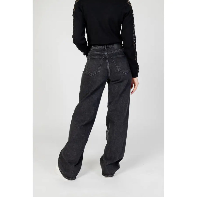 Women’s black wide leg denim jeans shown from the back with a faded wash and classic back pockets
