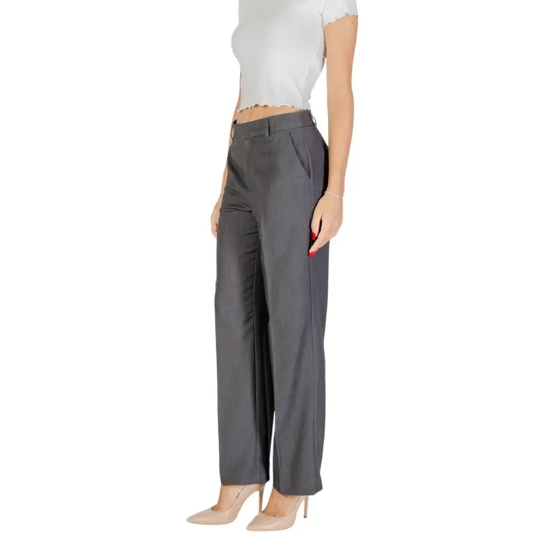 Women’s dark grey wide-leg trousers with white ruffled crop top and nude high heels