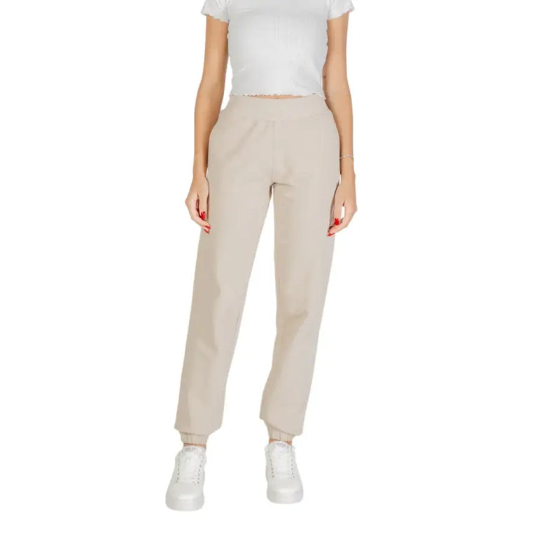 Women’s light beige cropped sweatpants with front pockets, white t-shirt, and sneakers