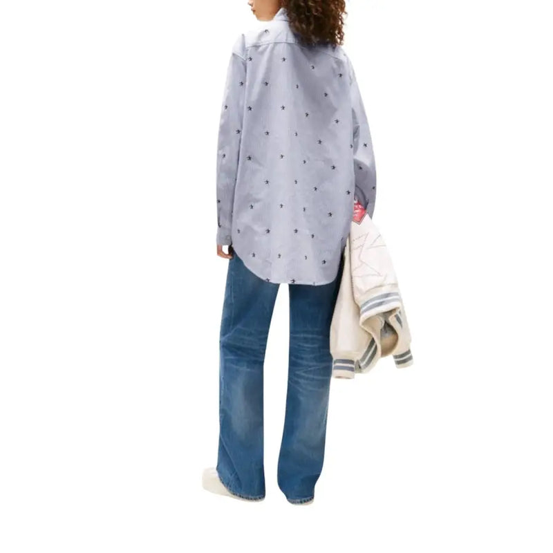 Women wearing light blue patterned button-up shirt with wide-leg jeans and striped jacket