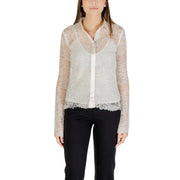 Women’s sheer white lace button-up shirt with long sleeves and scalloped hem over a white camisole paired with black trousers